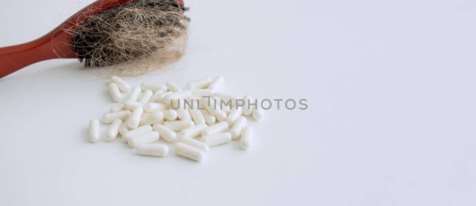 hair brush with hair and vitamins. hair loss.