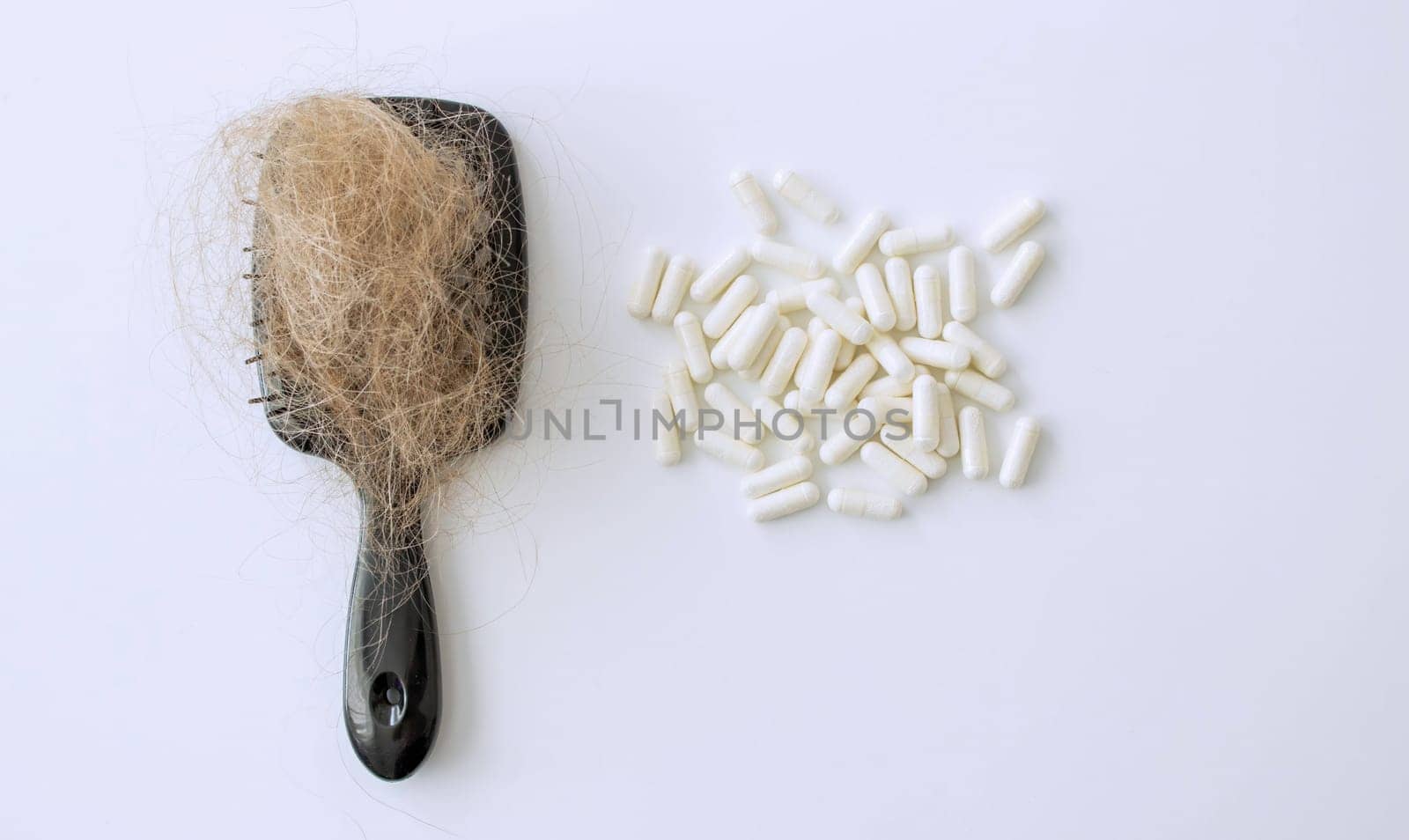 hair brush with hair and vitamins. hair loss.
