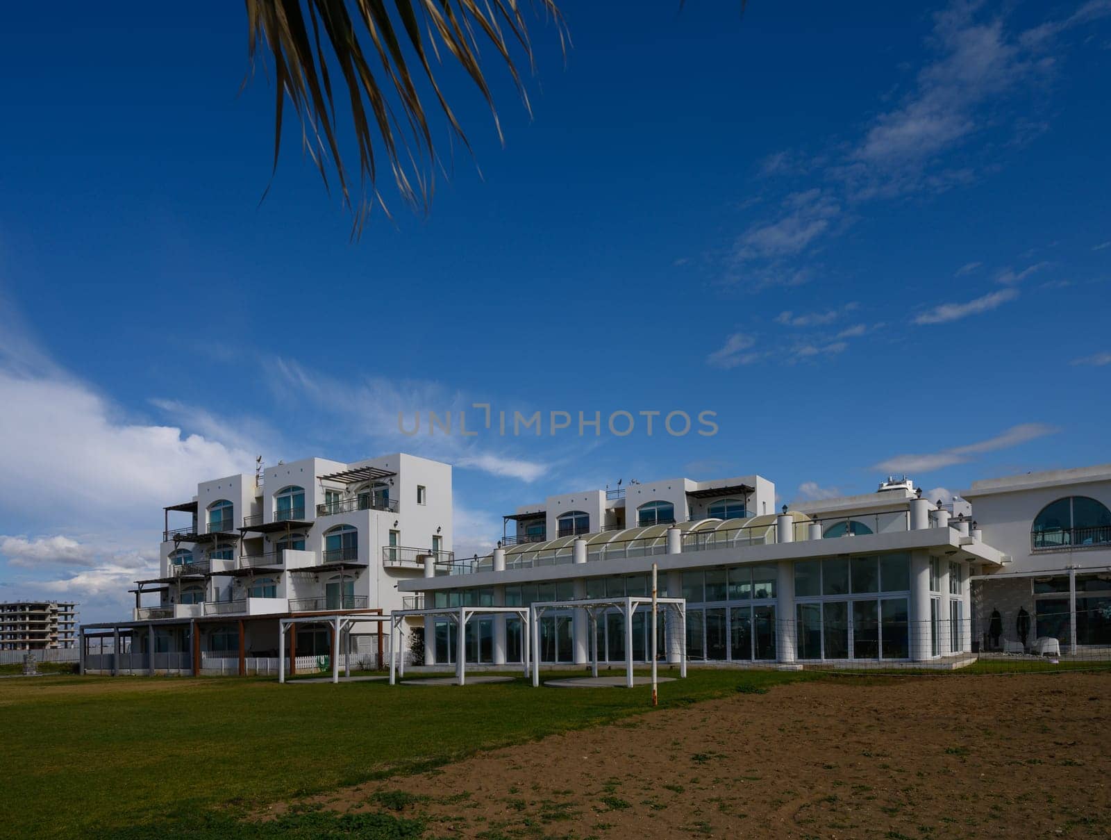 Serene coastal retreat showcases stunning modern design against a vibrant blue sky, inviting relaxation and exploration.