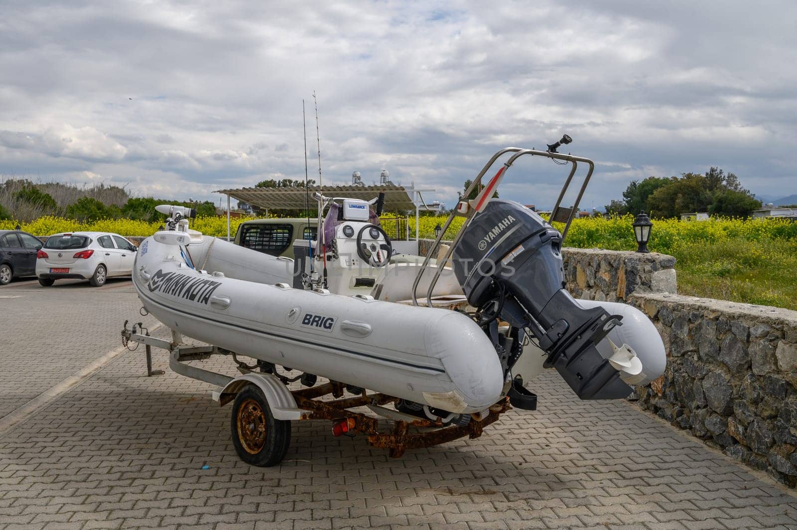 Gaziveren Cyprus -01.03.2025 A sleek inflatable boat rests on a trailer in a parking area, ready for exploration as clouds loom above.