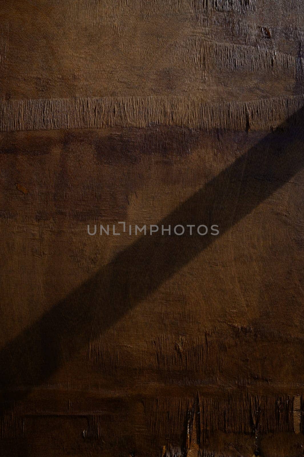Soft light casts a long shadow on rugged wood, revealing the natural beauty of the grain and creating a peaceful vibe.