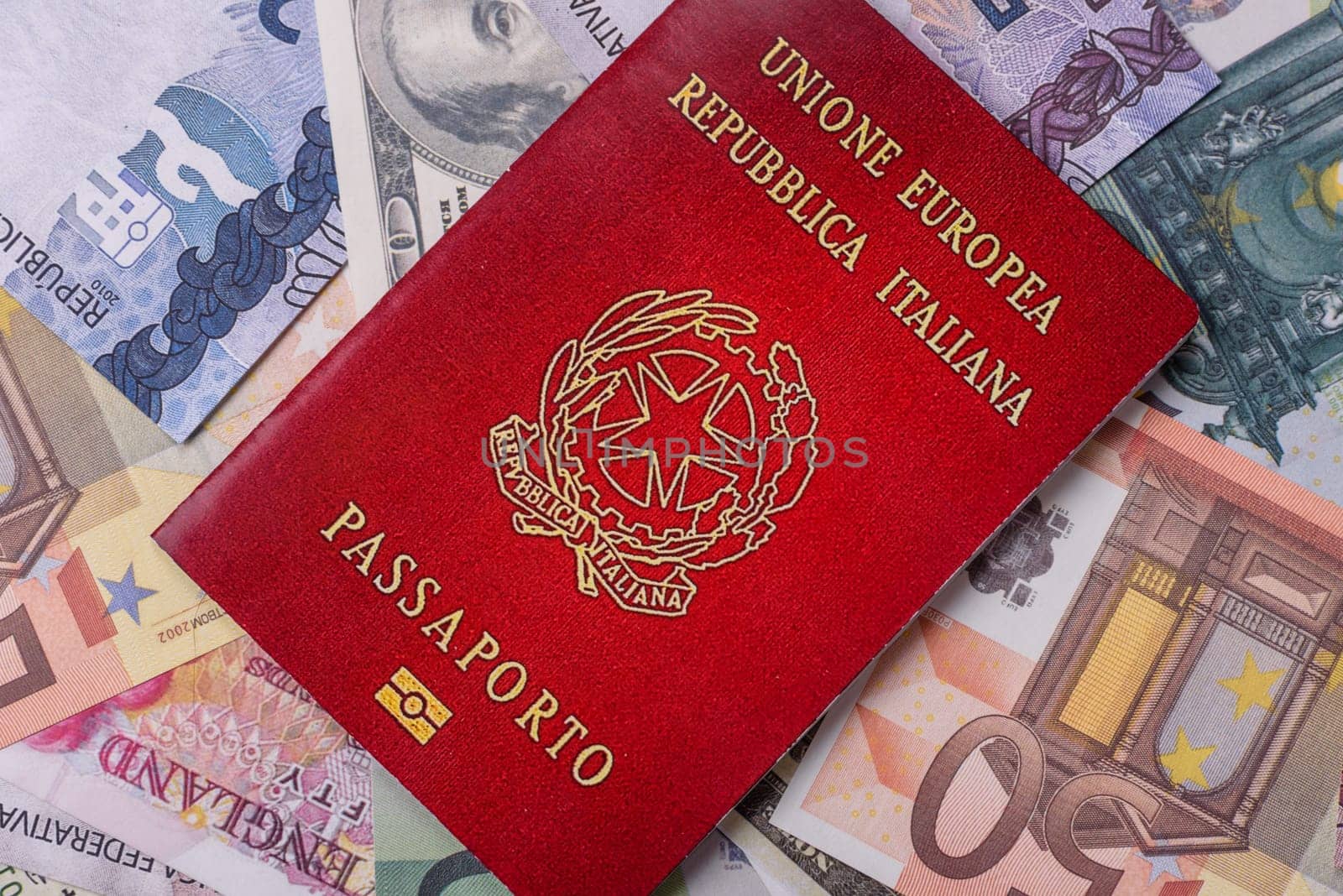 International passport of a citizen of Italy on background of paper banknotes of different countries