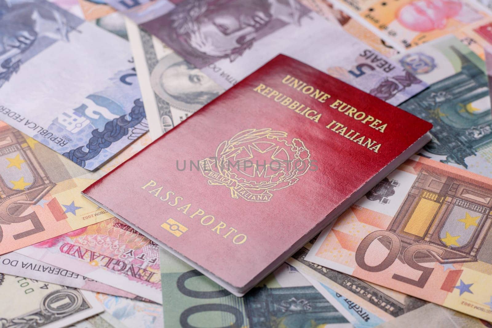 International passport of a citizen of Italy on background of paper banknotes of different countries