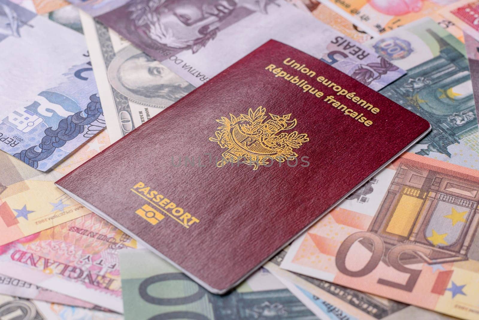 International passport of a citizen of France on background of paper banknotes of different countries