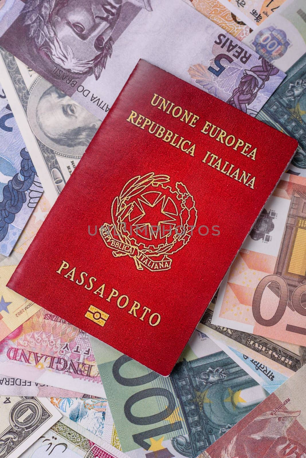 International passport of a citizen of Italy on background of paper banknotes of different countries