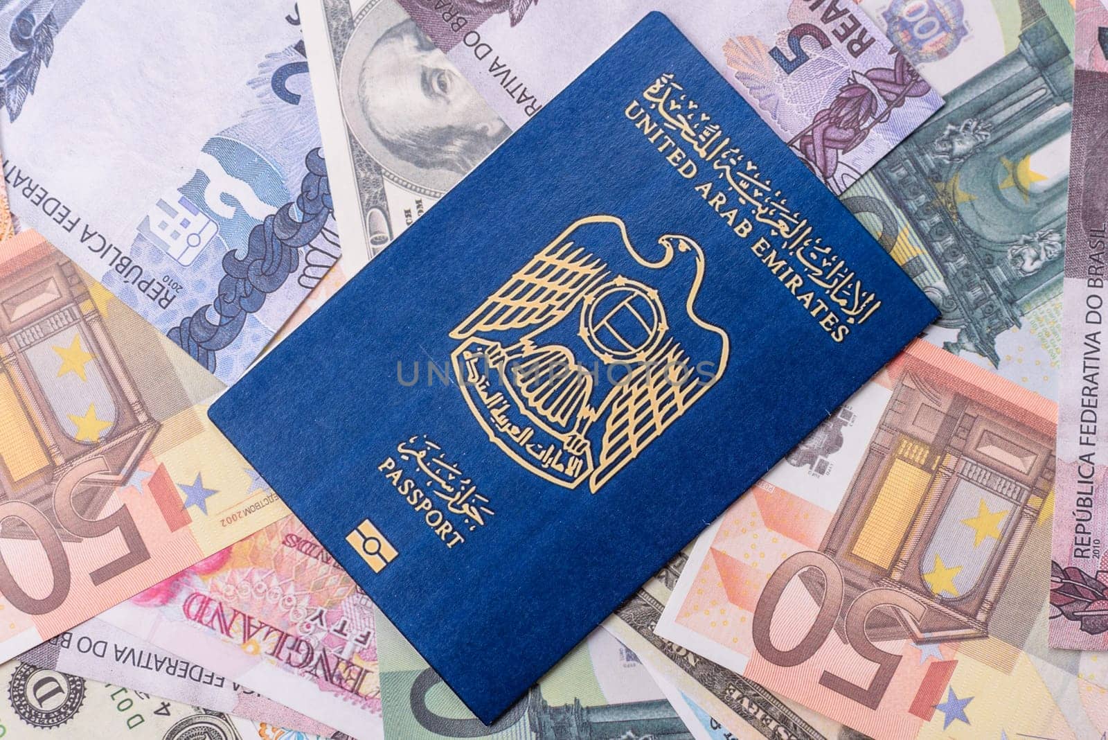 International passport of a citizen of United Arab Emirates against the paper banknotes