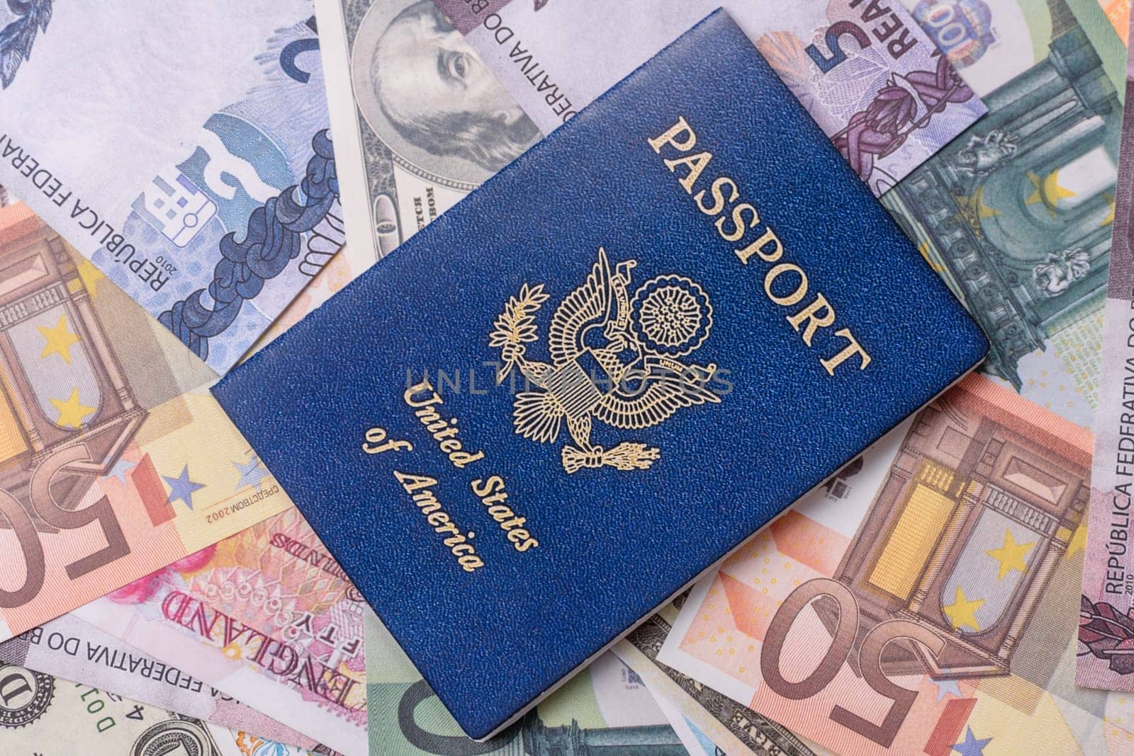 International passport of a citizen of USA on background of paper banknotes of different countries