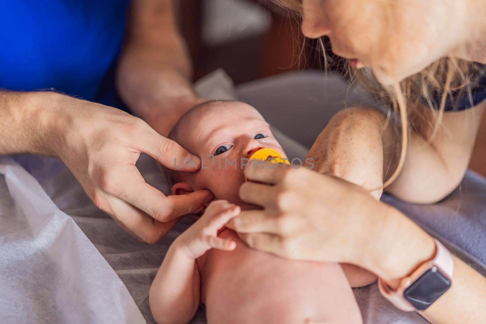 A newborn baby receives gentle osteopathic care, lying calmly while the specialist carefully examines and adjusts the infant. A moment of professional pediatric care, early development, and holistic well-being, symbolizing health and nurturing touch.