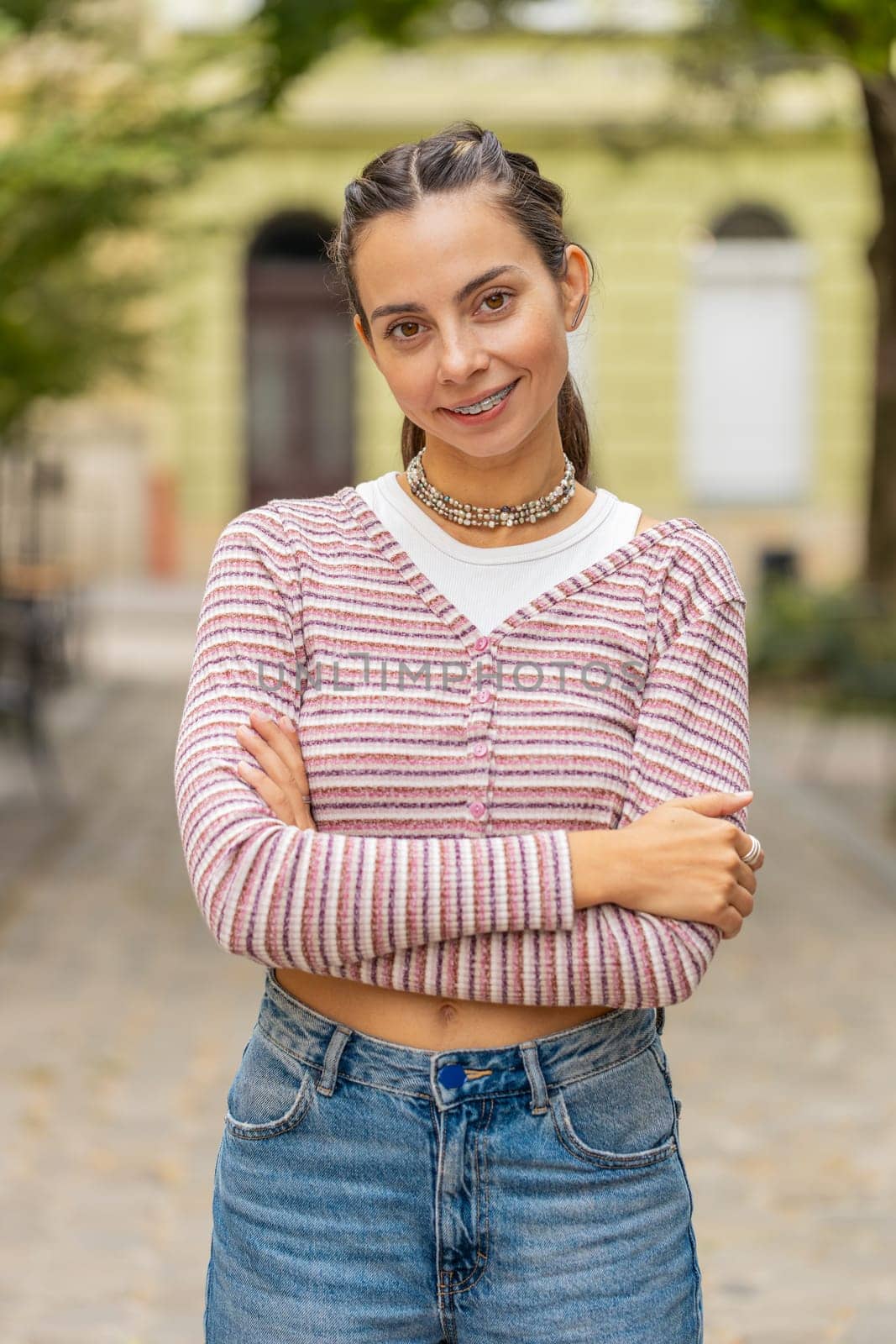 Portrait of happy young woman face with teeth braces smiling friendly open eyes glad expression looking dreaming resting relaxation feel satisfied good news outdoors. Pretty adult girl on city street