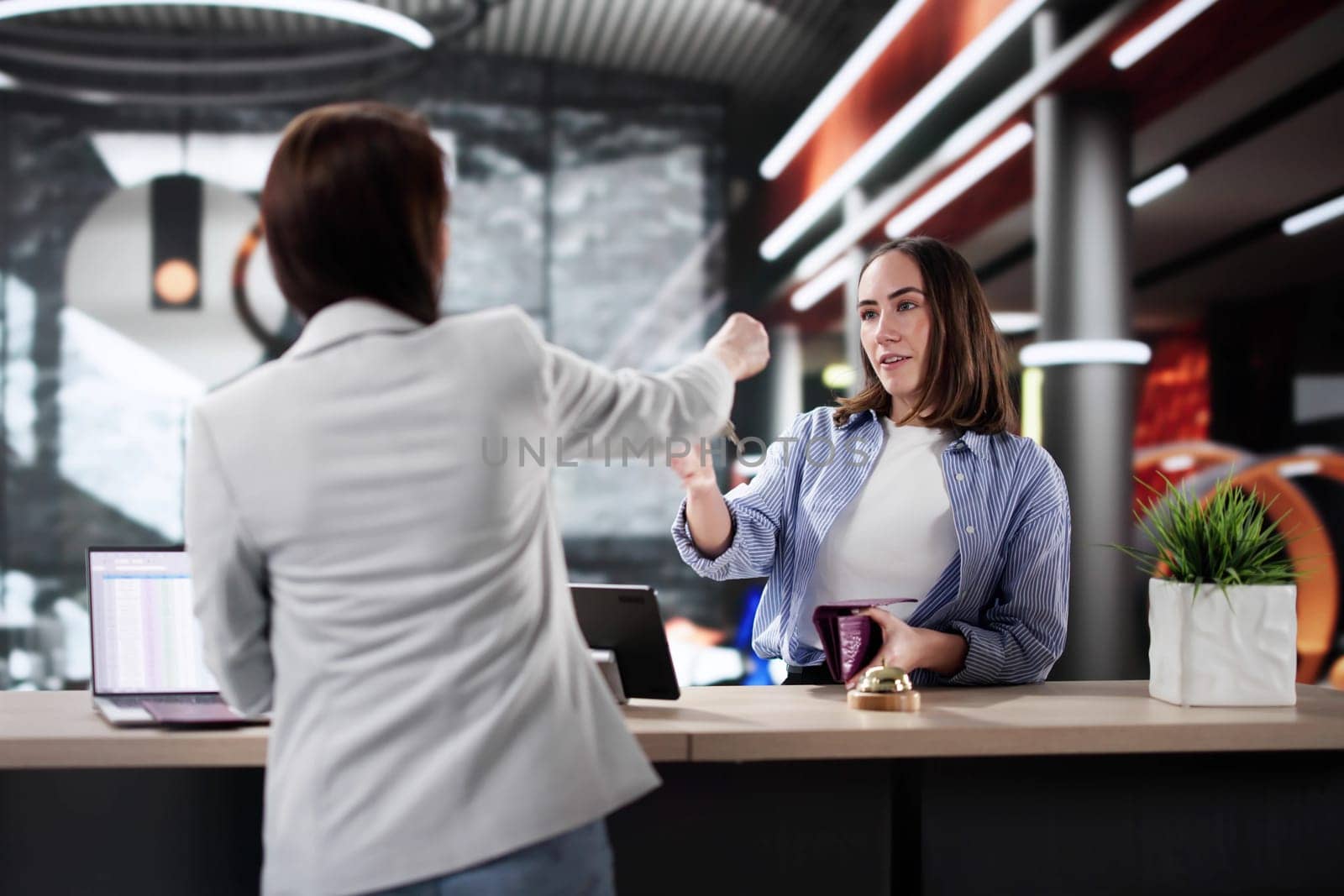 Professional Woman Discussing Reservation with Hotel Receptionist, Business Trip Lifestyle