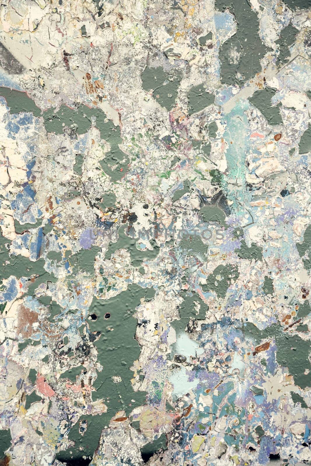 Peeling paint texture on a weathered urban wall in soft pastel and earthy tones. A perfect backdrop for creative projects, grunge aesthetics, and abstract art.