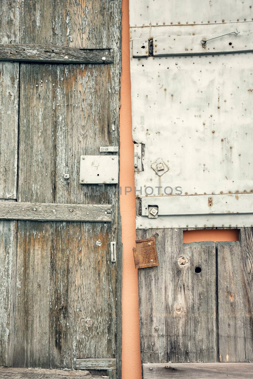 A rustic wooden door and a weathered metal door side by side, creating a unique contrast of textures and materials. Perfect for vintage, architectural, and industrial design projects