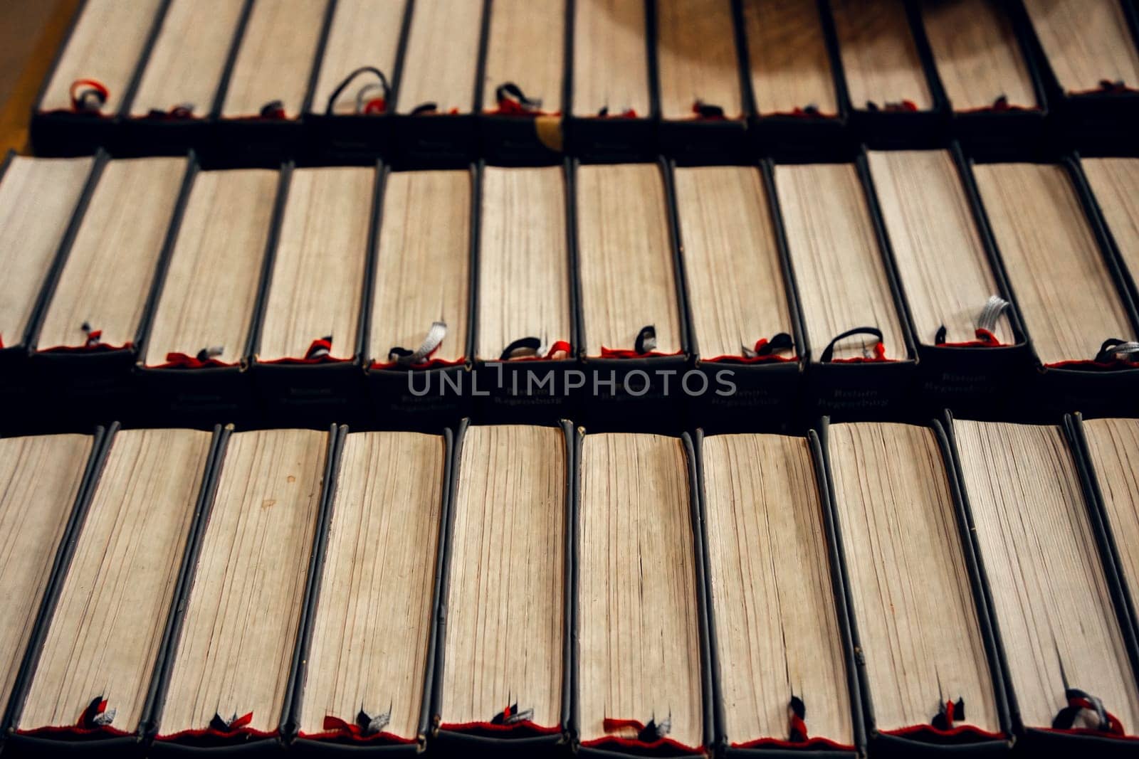 A row of antique books with worn pages and ribbon bookmarks in a historical library. Perfect for themes of literature, knowledge, history, and classical education.