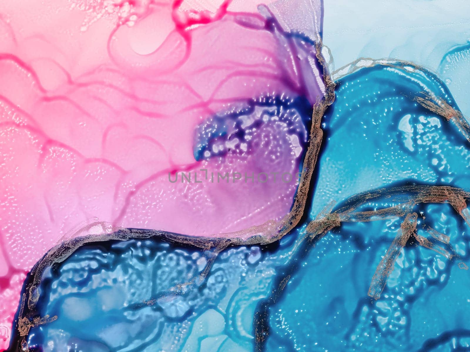 Alcohol ink fluid art. Waves in blue and pink colors with liquid golden inclusion. Abstract gradient background or texture