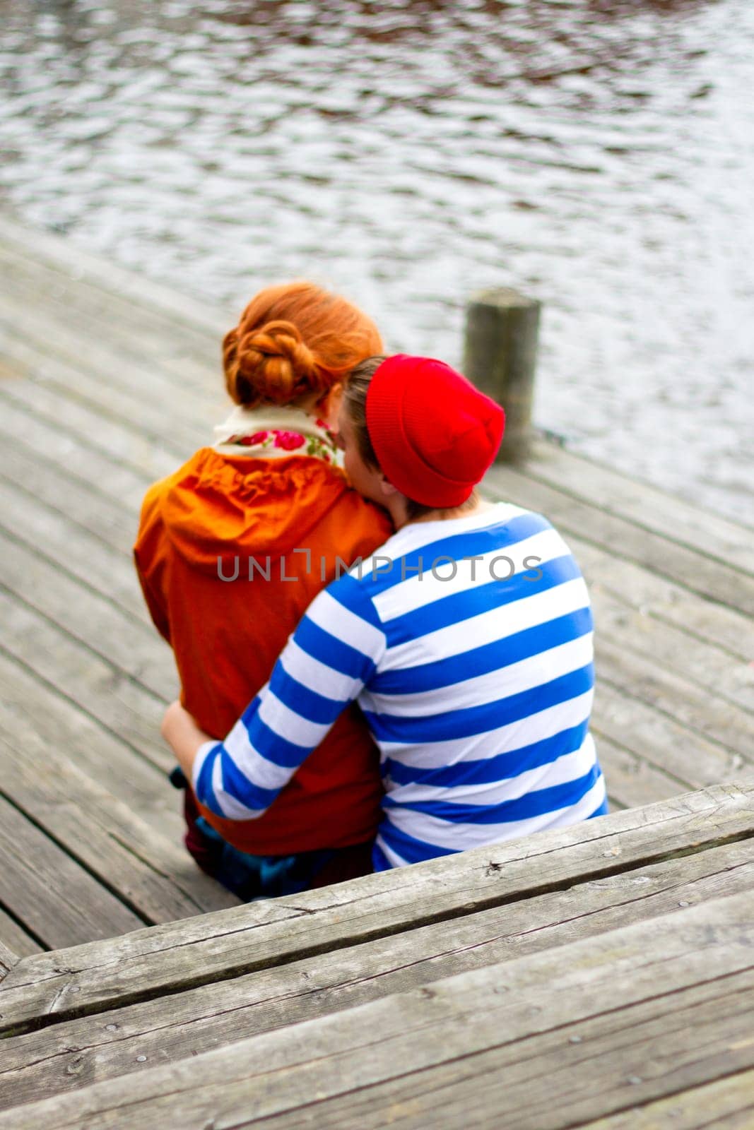 young couple in love sits tenderly hugging on a pier, love and care