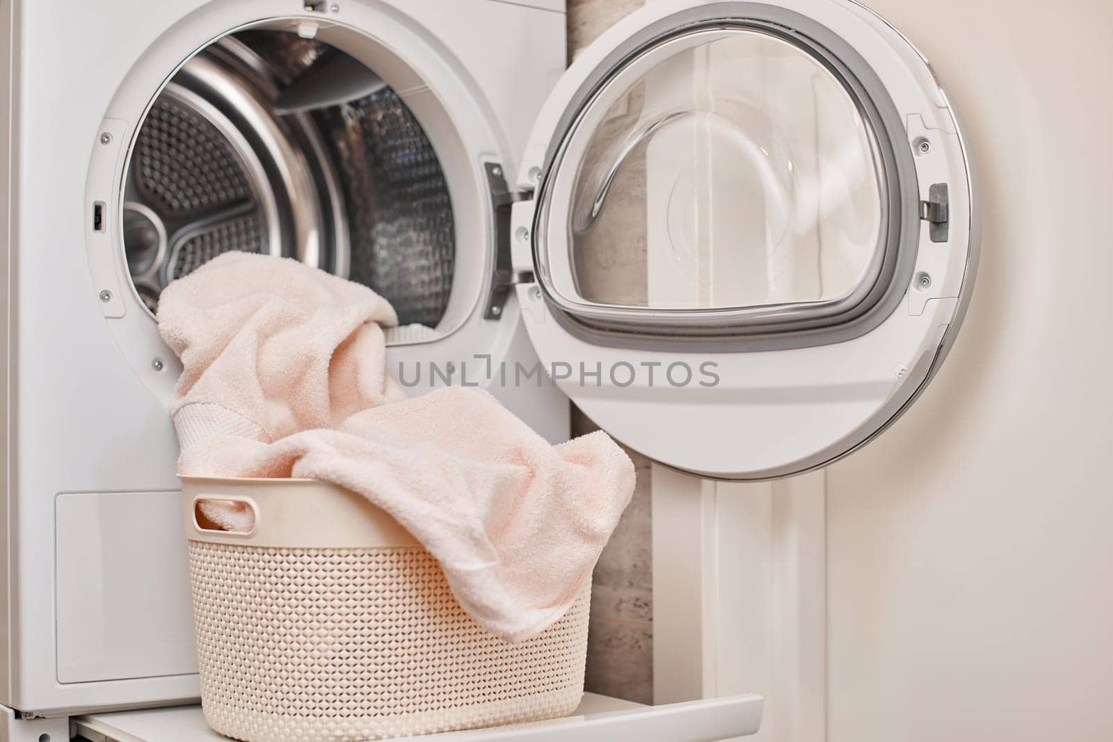 Modern washing machine and basket with laundry, laundry room