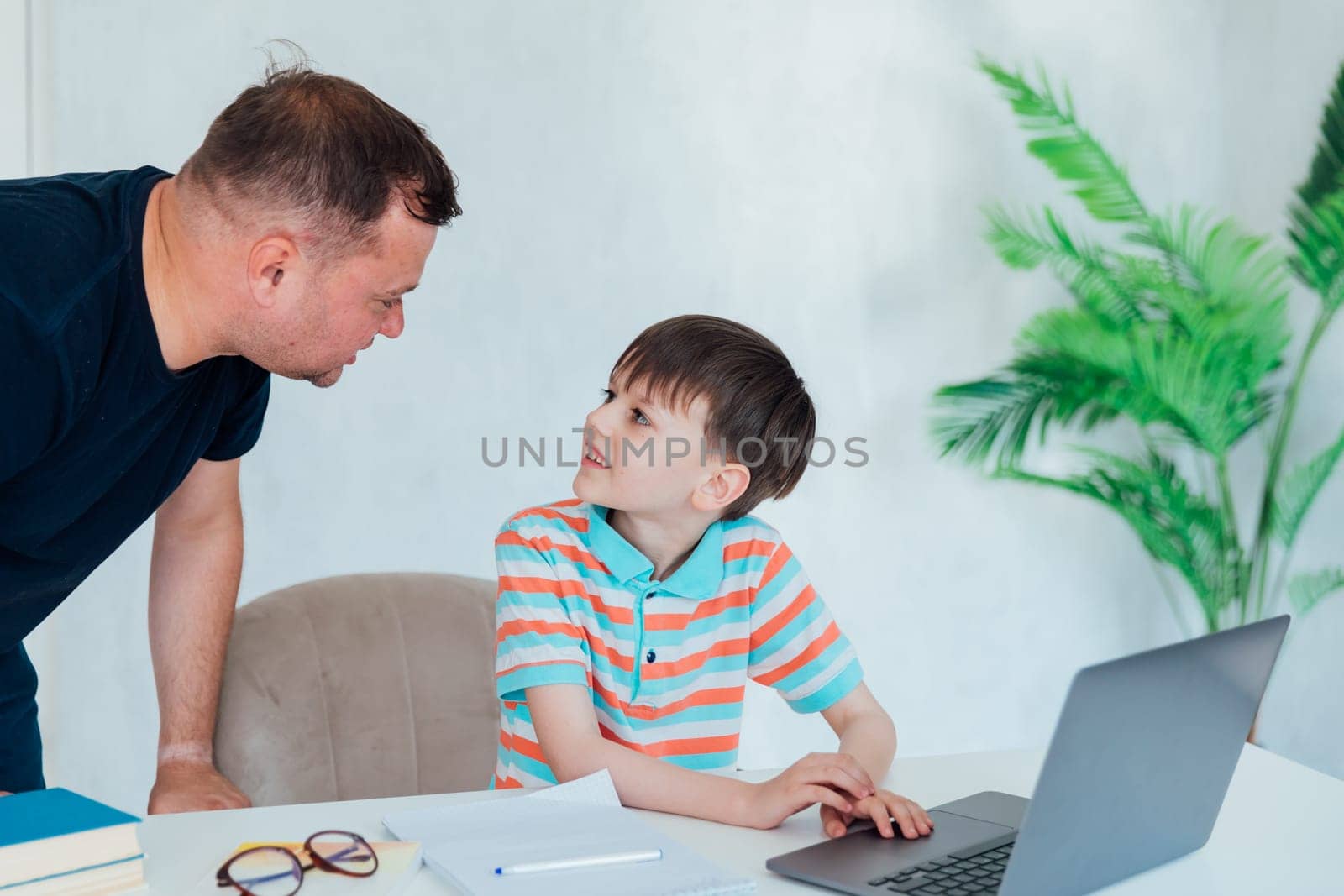 teacher helps boy with laptop