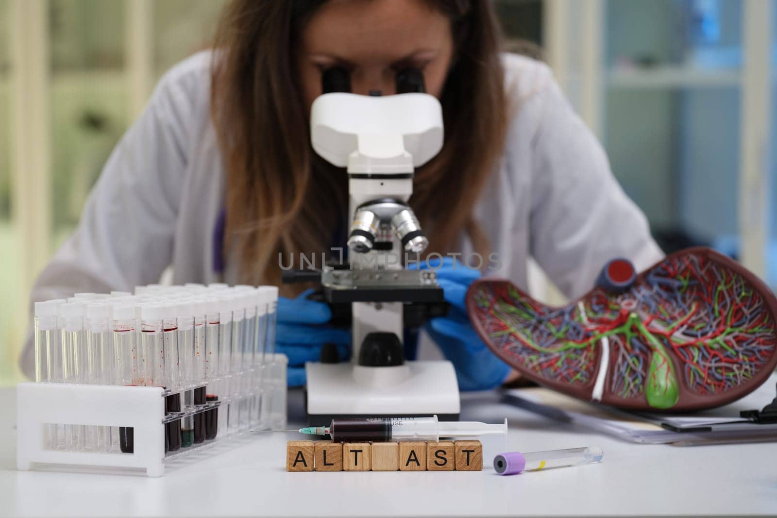 In a modern laboratory environment, a dedicated scientist meticulously examines various specimens through a microscope