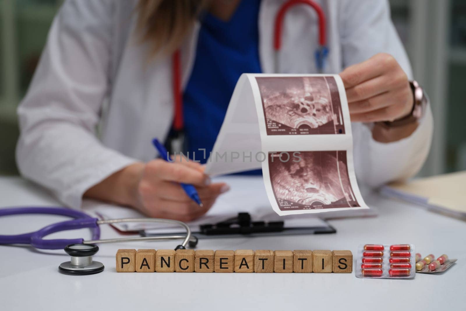 A dedicated healthcare professional meticulously reviewing pancreatitis images with medication spread across the table