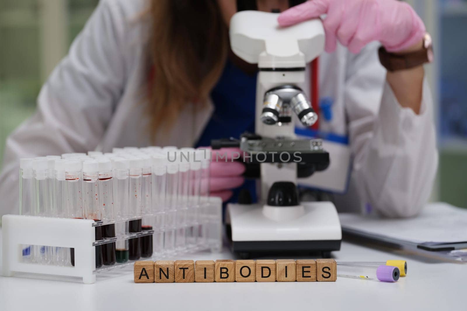 A skilled lab technician examines samples under a microscope, focusing on innovative antibodies research for health
