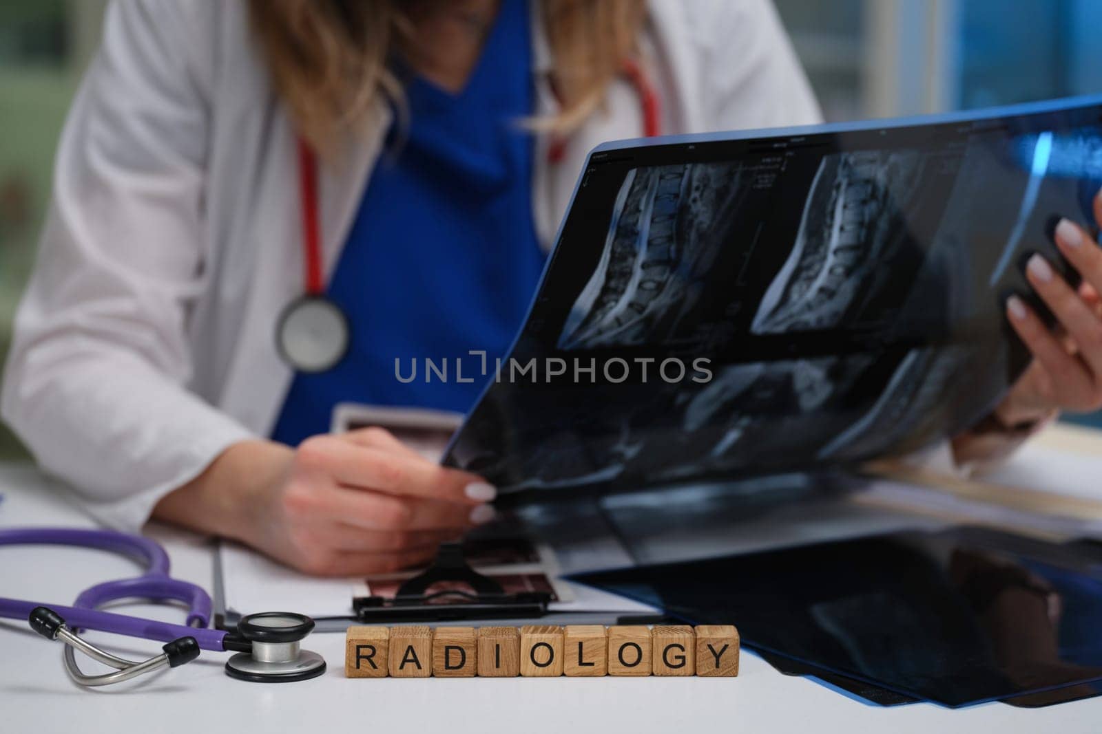 In a clinical environment, a radiologist expertly analyzes Xray images while using a stethoscope during their work