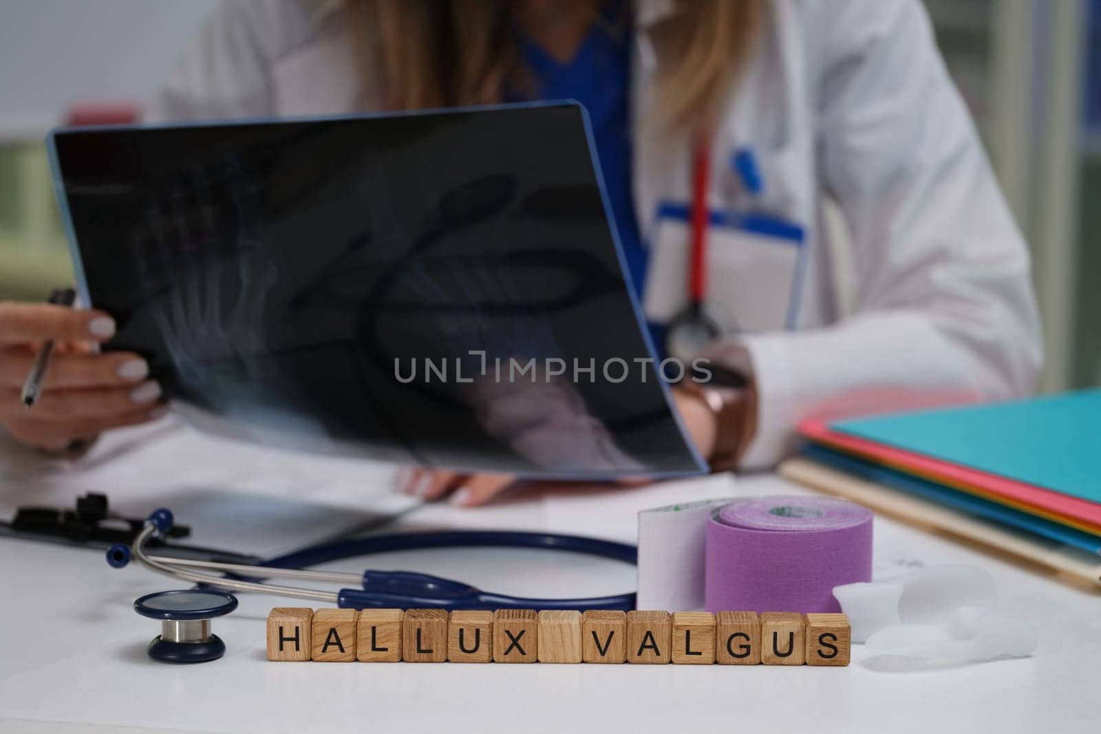 A doctor is carefully examining an Xray image to diagnose hallux valgus using various medical tools