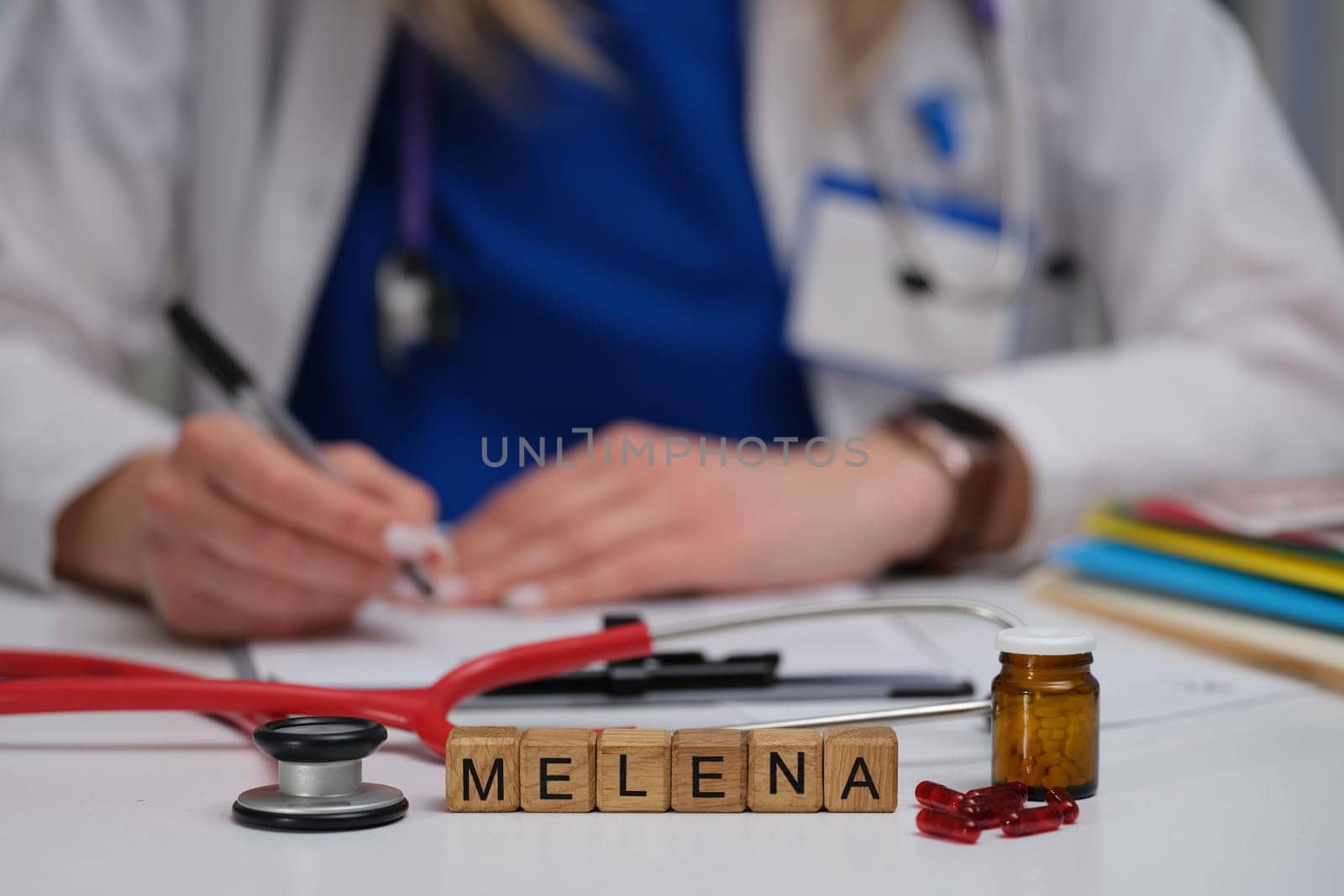 A healthcare worker writes notes on melena with medical items for better understanding and documentation