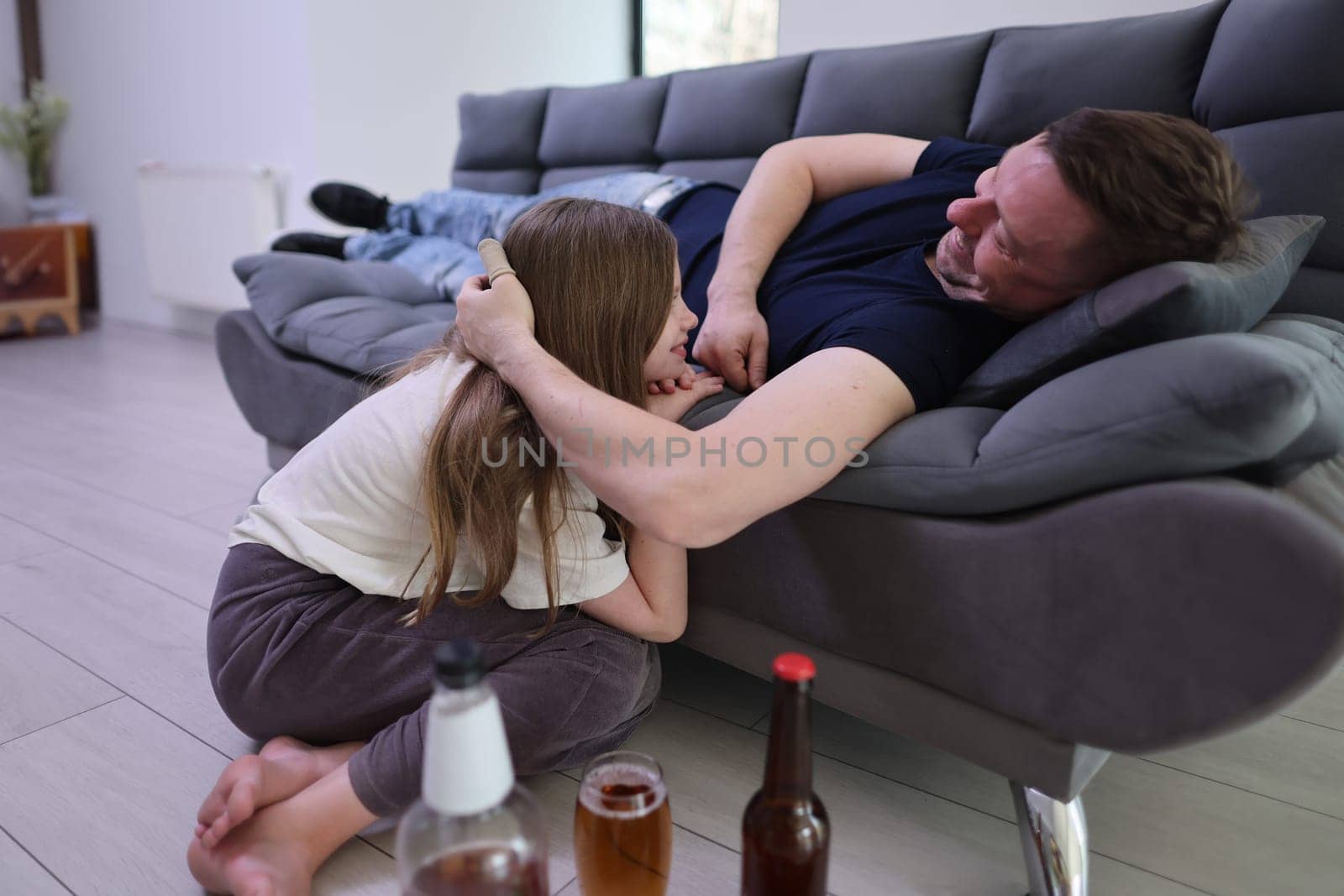 A joyful and heartwarming moment of a child playfully and happily interacting with an adult on a comfy sofa
