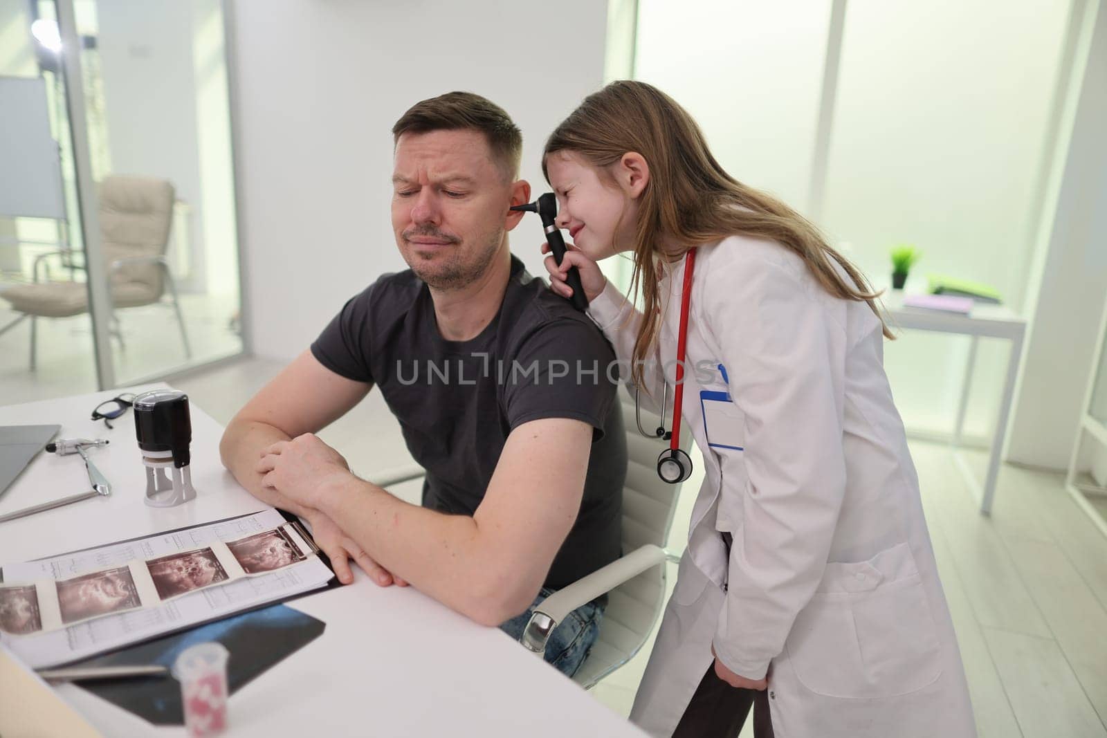 A doctor examines a male patient in a contemporary medical clinic, showcasing healthcare interaction.