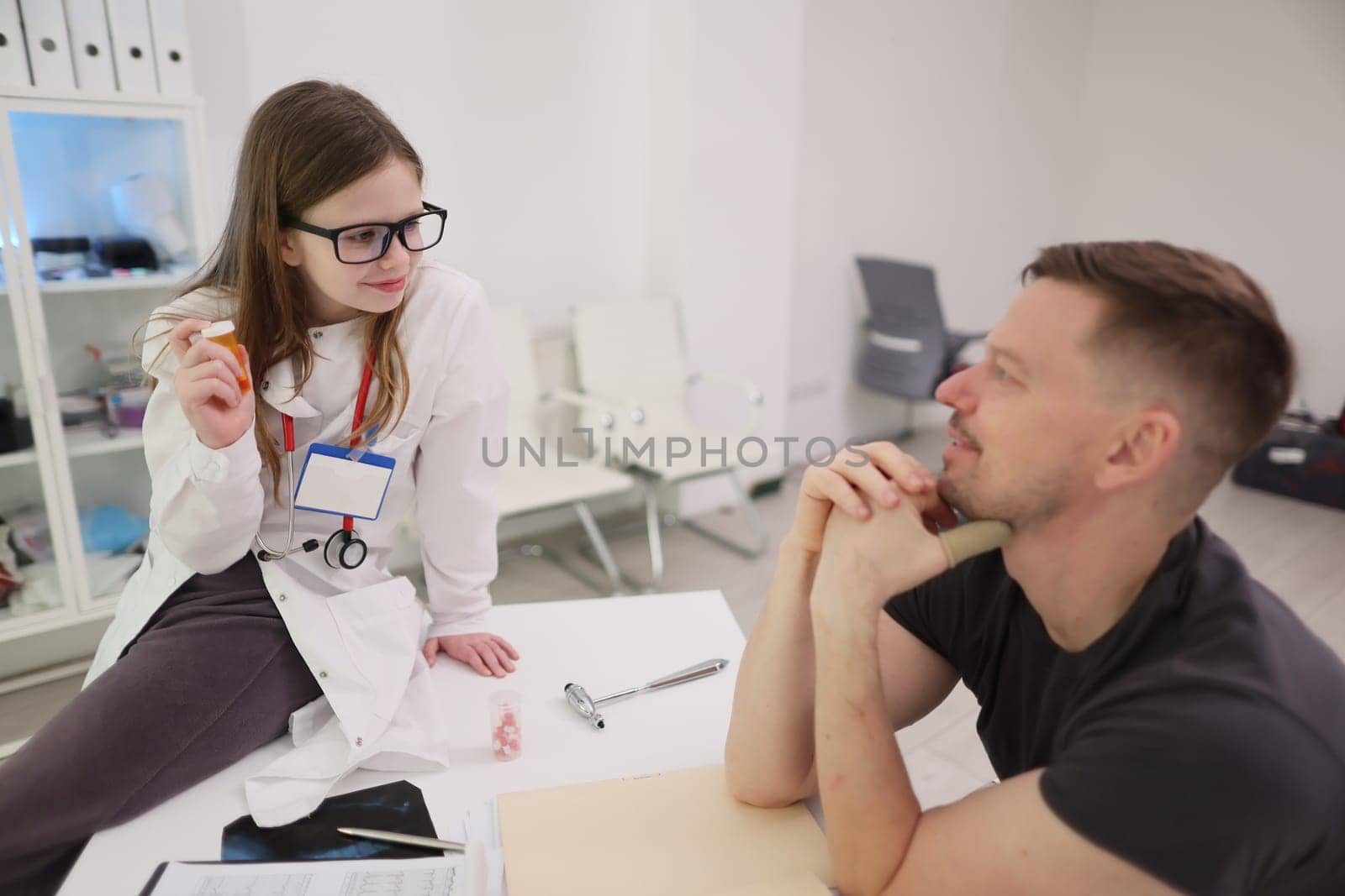 In a contemporary healthcare environment, a young female doctor provides consultation for her male patient