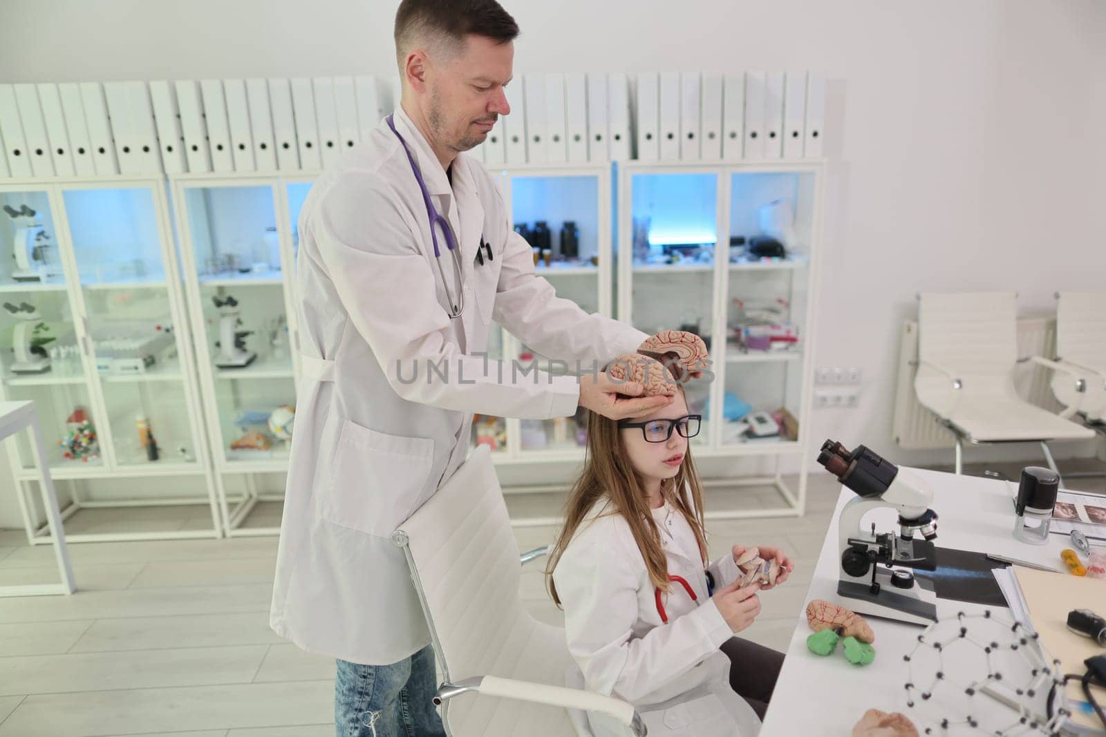 In a vibrant and brightly lit laboratory, a young girl eagerly explores and conducts experiments with her mentor