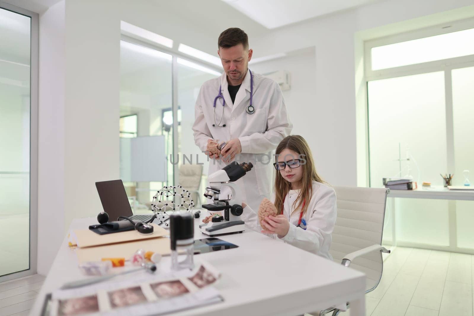 In a lab, a dedicated doctor and a curious girl unite to explore the marvelous wonders of science together