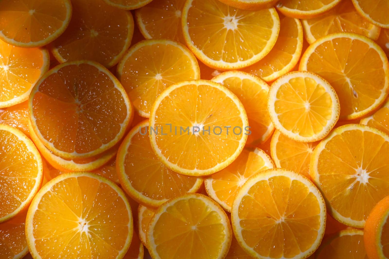Bright and juicy orange slices spread out under warm sunlight, creating a lively, energetic feast for the eyes.