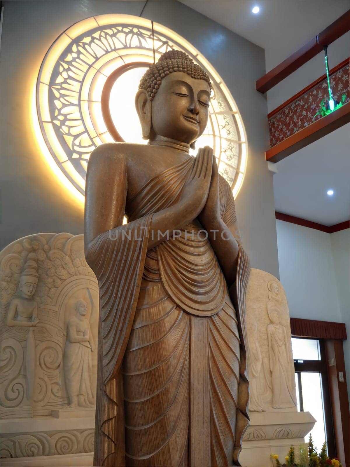 A detailed statue of Lord Buddha in a peaceful prayer posture with a halo, set in a serene environment.