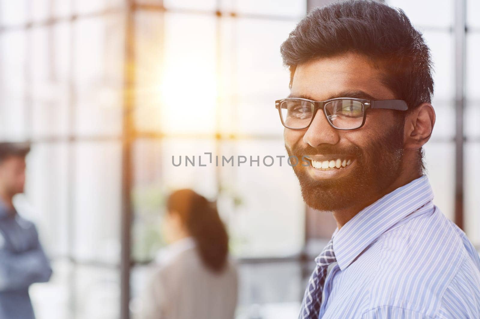 male investor beard looking at camera and smiling in modern office