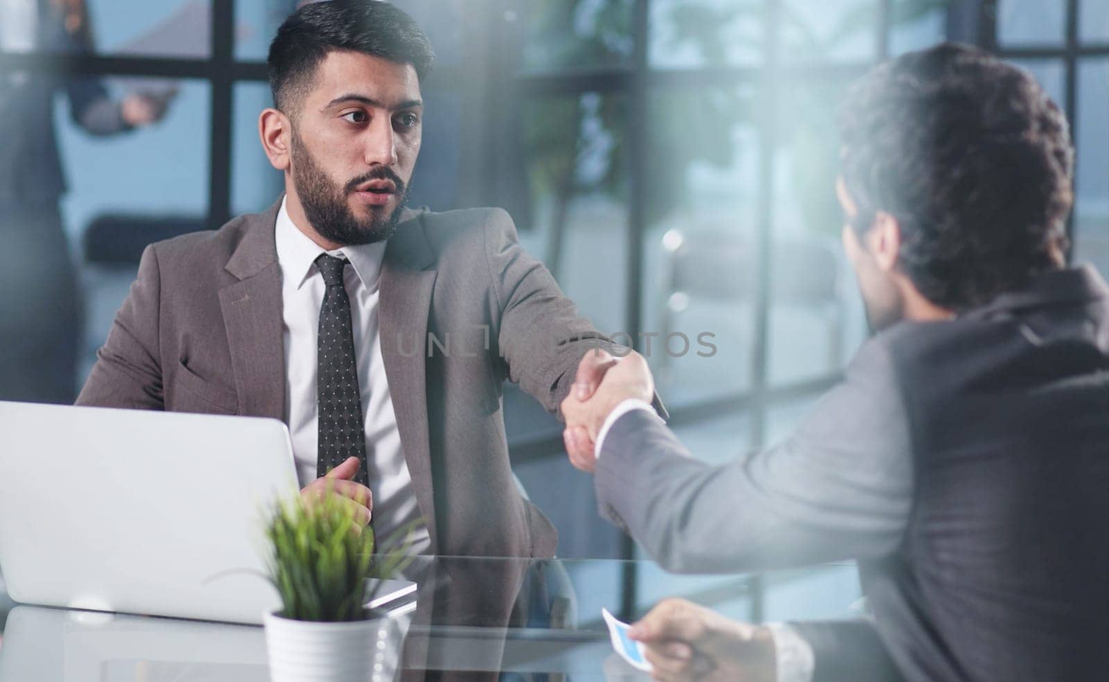 Male hand shaking hand over office desk