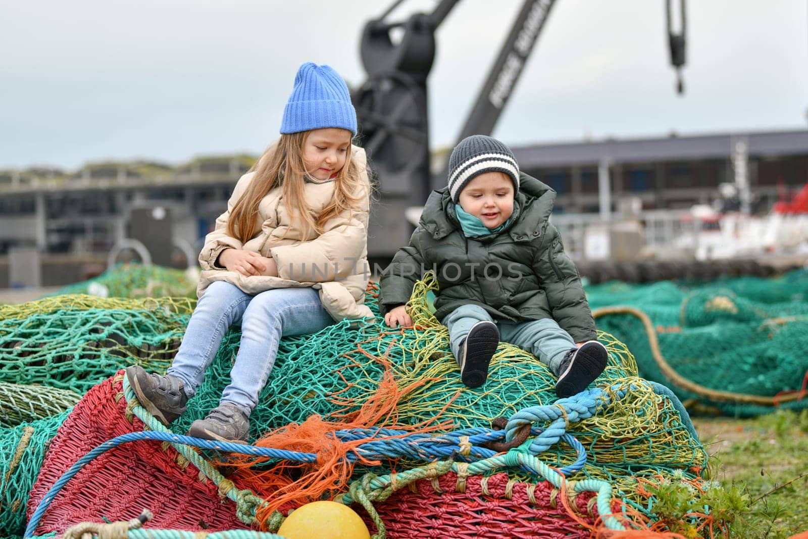 Brother and sister playing at the fishing nets