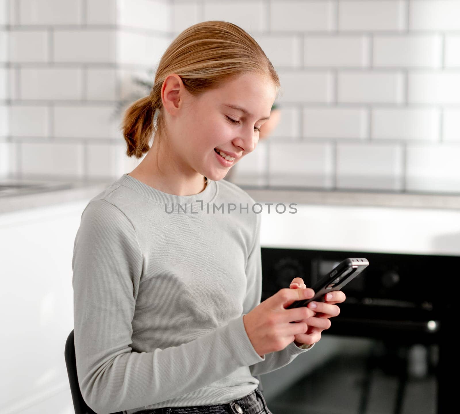 Cute Little Girl Playing An Online Game On Smartphone At Home