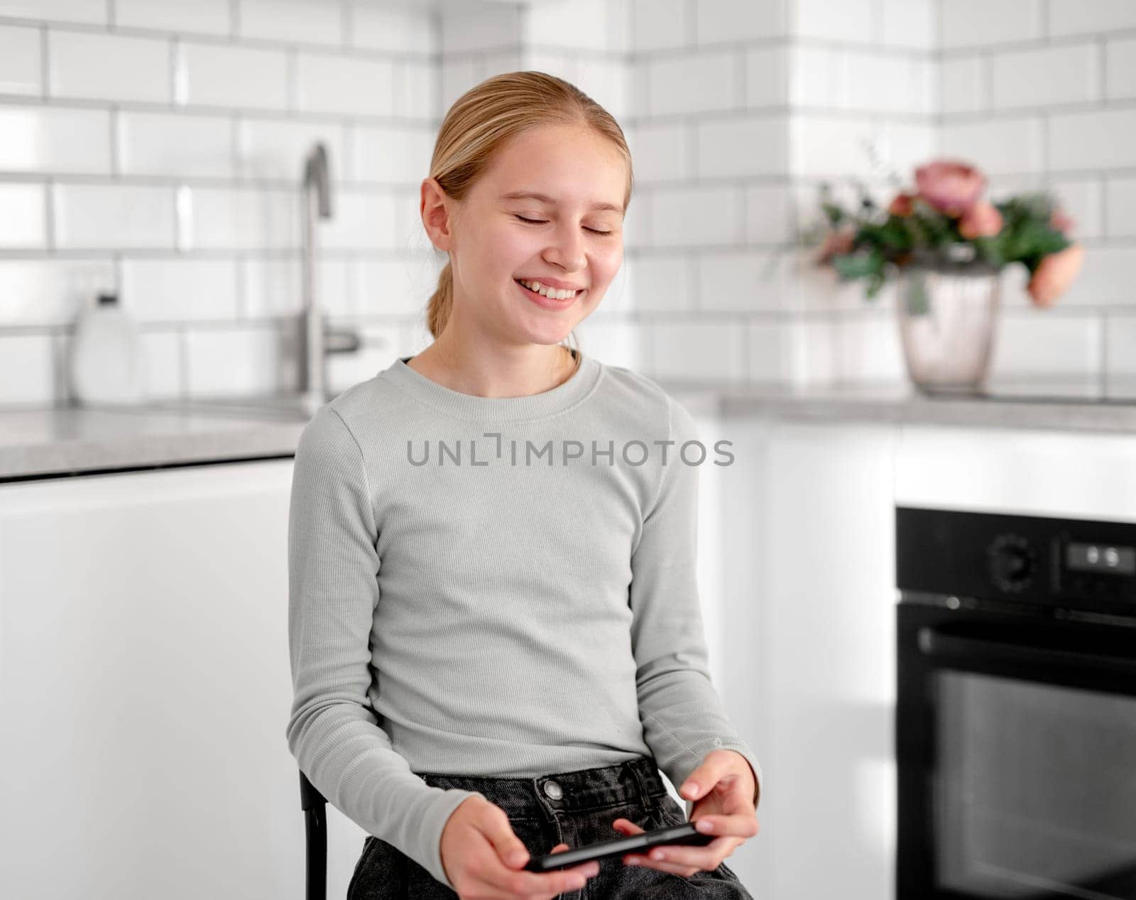 Cute Little Girl Happily Playing An Online Game On Smartphone