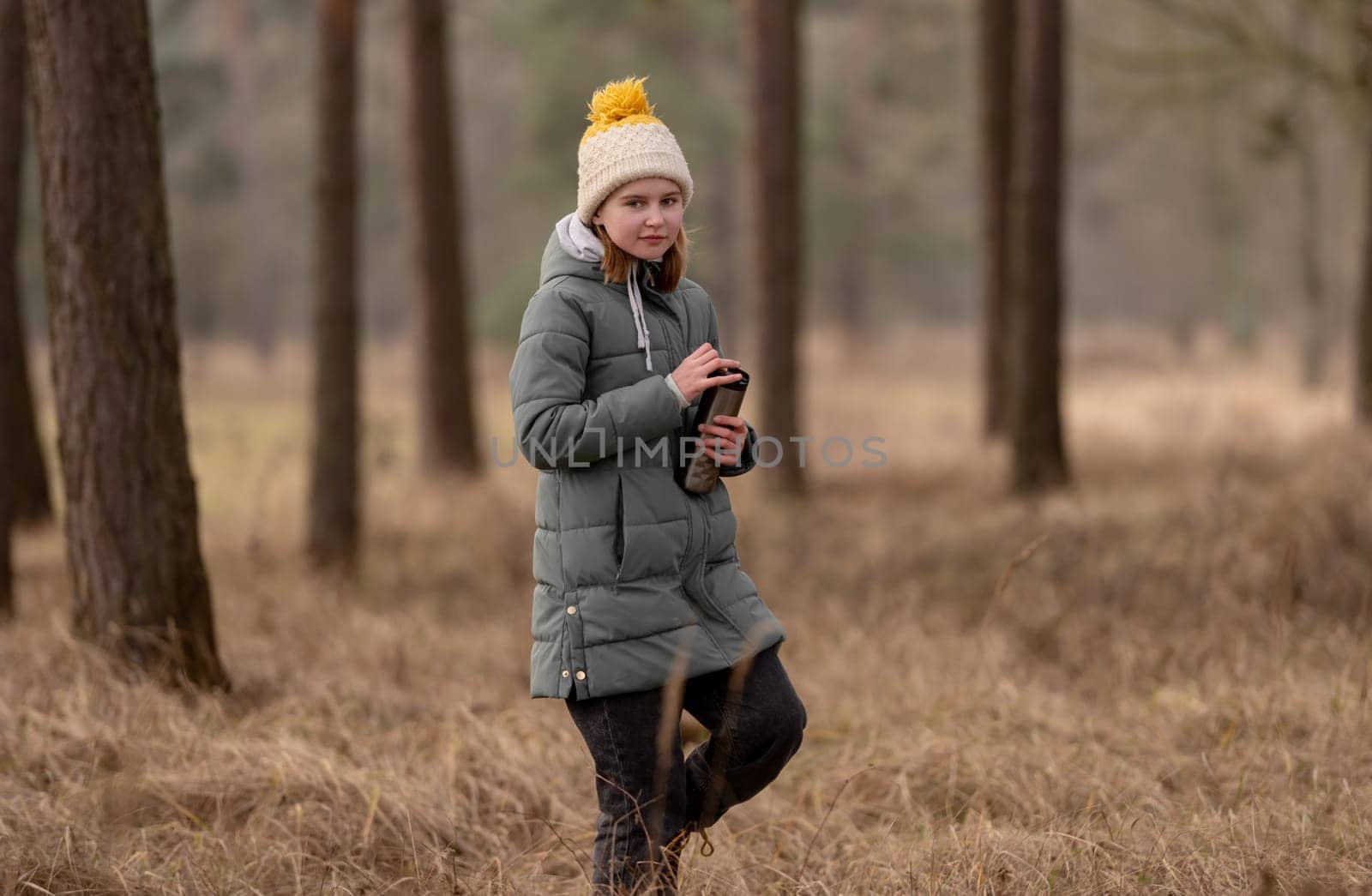 Girl With Thermos Walks In The Forest In Early Spring