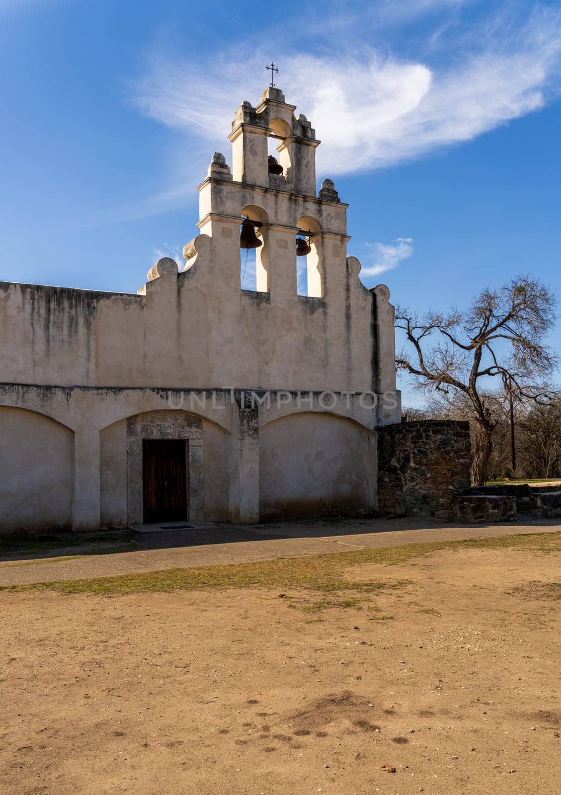 San Juan mission church is a historic landmark near San Antonio, Texas, showcasing its weathered facade under a clear sky.
