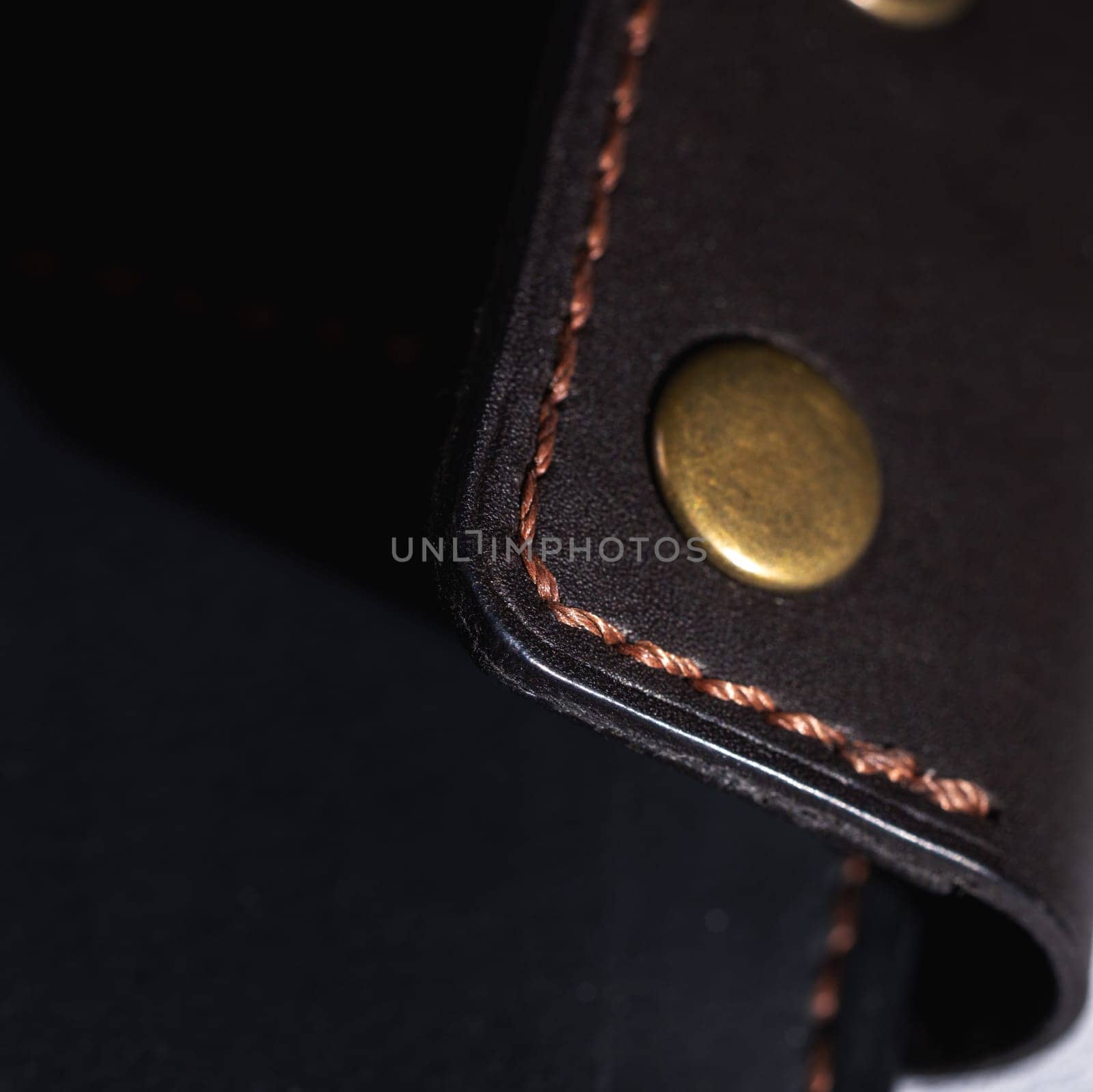 Close up showcasing the craftsmanship of a leather wallet, highlighting the detailed stitching and brass rivets