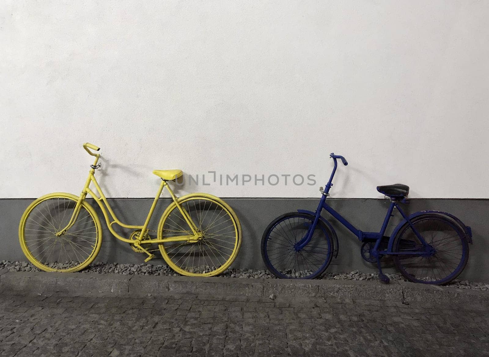 yellow and blue bicycles on white wall background.copy space. High quality photo