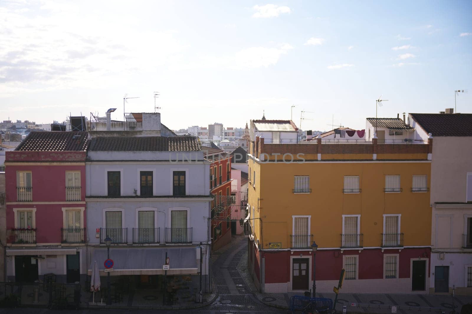 View of traditional colorful residential buildings with balconies and narrow streets in the historic center of Badajoz, Spain.