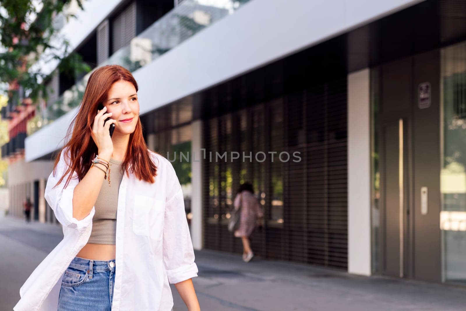 woman smiling happy while walking in a good mood talking on cell phone, concept of technology of communication and urban lifestyle, copyspace for text