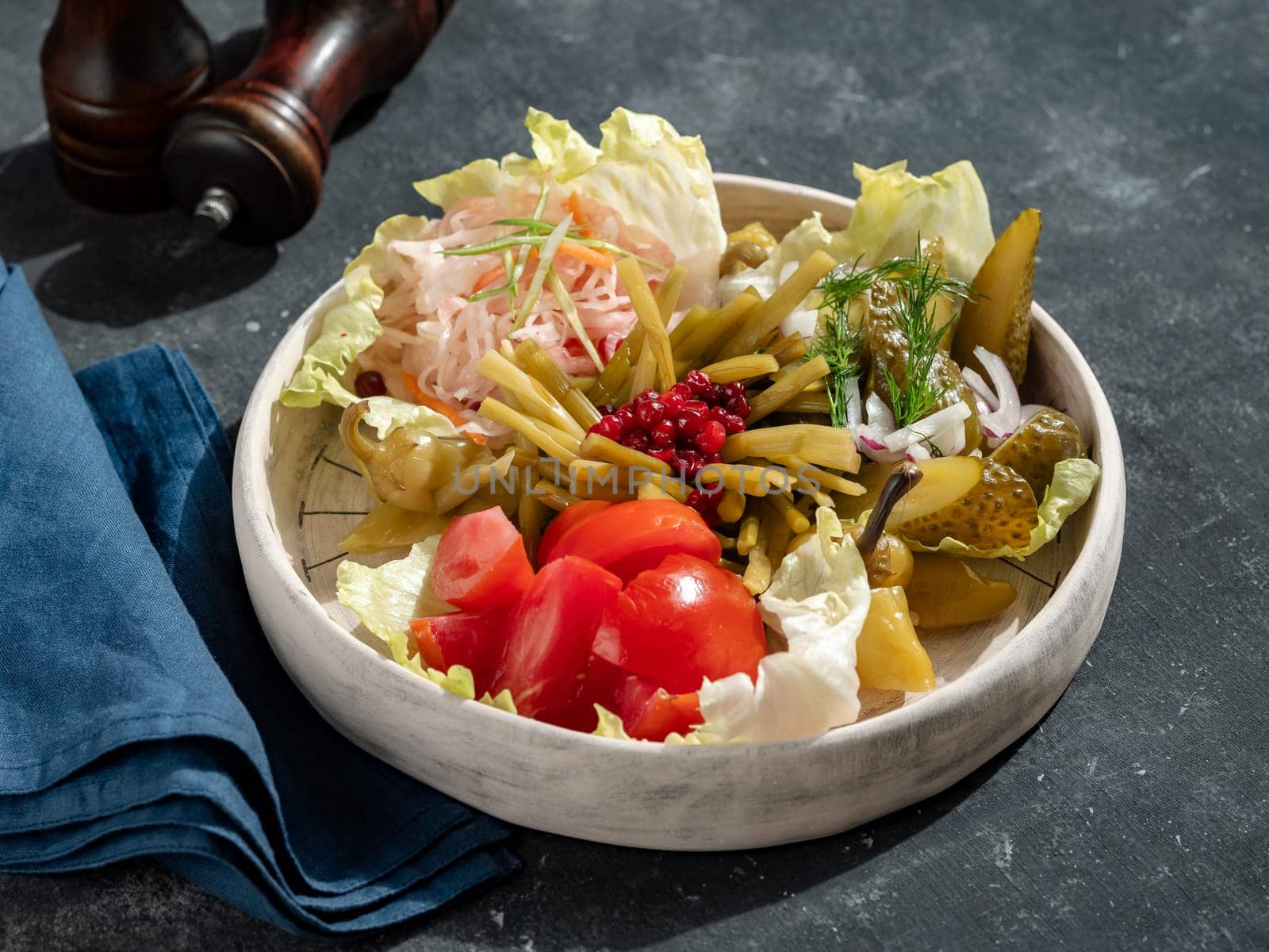 Assorted snacks from fermented cabbage, cucumbers and tomatoes, green bean. Decorated cranberry. Fermented healthy food concept. Pickled cucumbers, marinated tomatoes