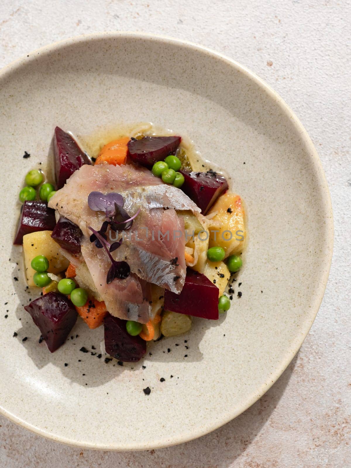 Restaurant dish with fish snack. Salted herring, potatoes, beets, carrots, green peas decorated microgreens. Pickled Herring Fish. Top view or flat lay