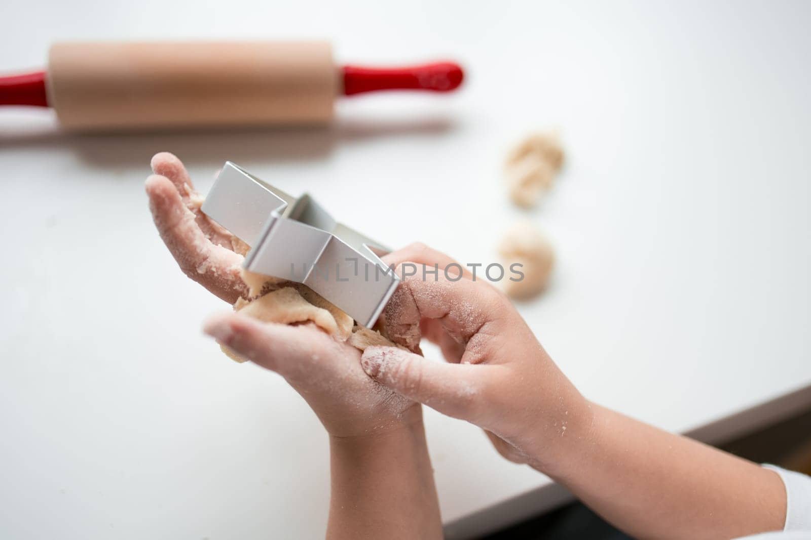 Child making cookies with dough and cutter.
