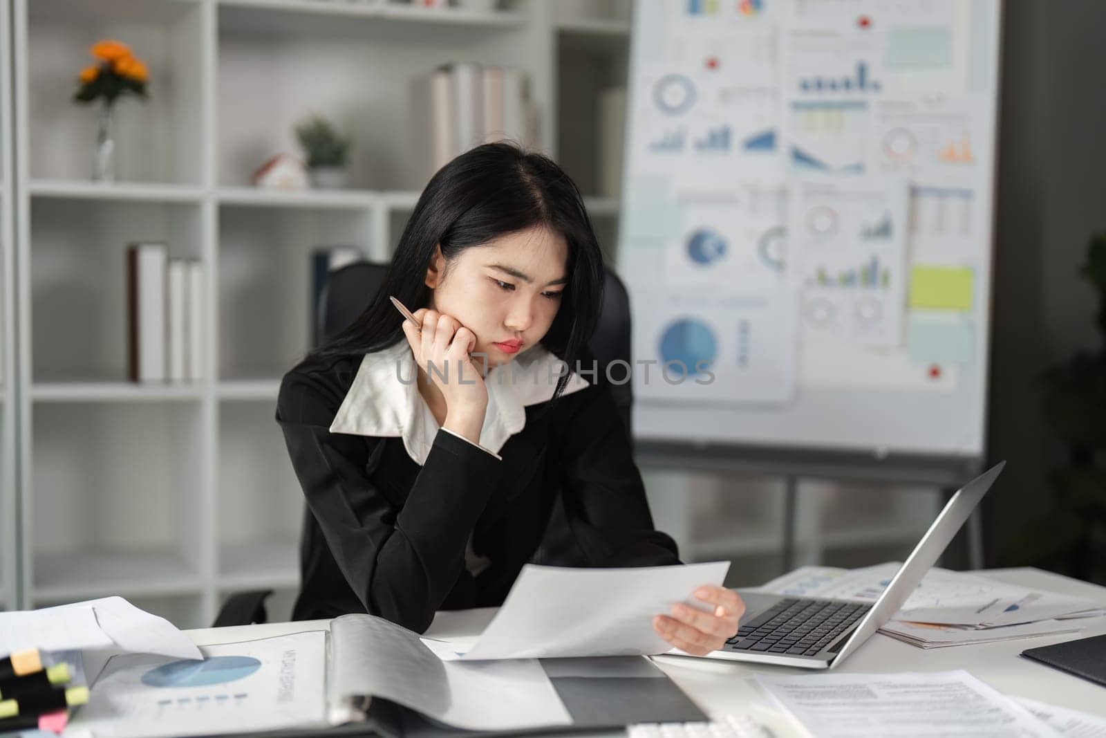 A dedicated businesswoman studies financial reports, emphasizing her commitment to accuracy in tax filing and financial management.