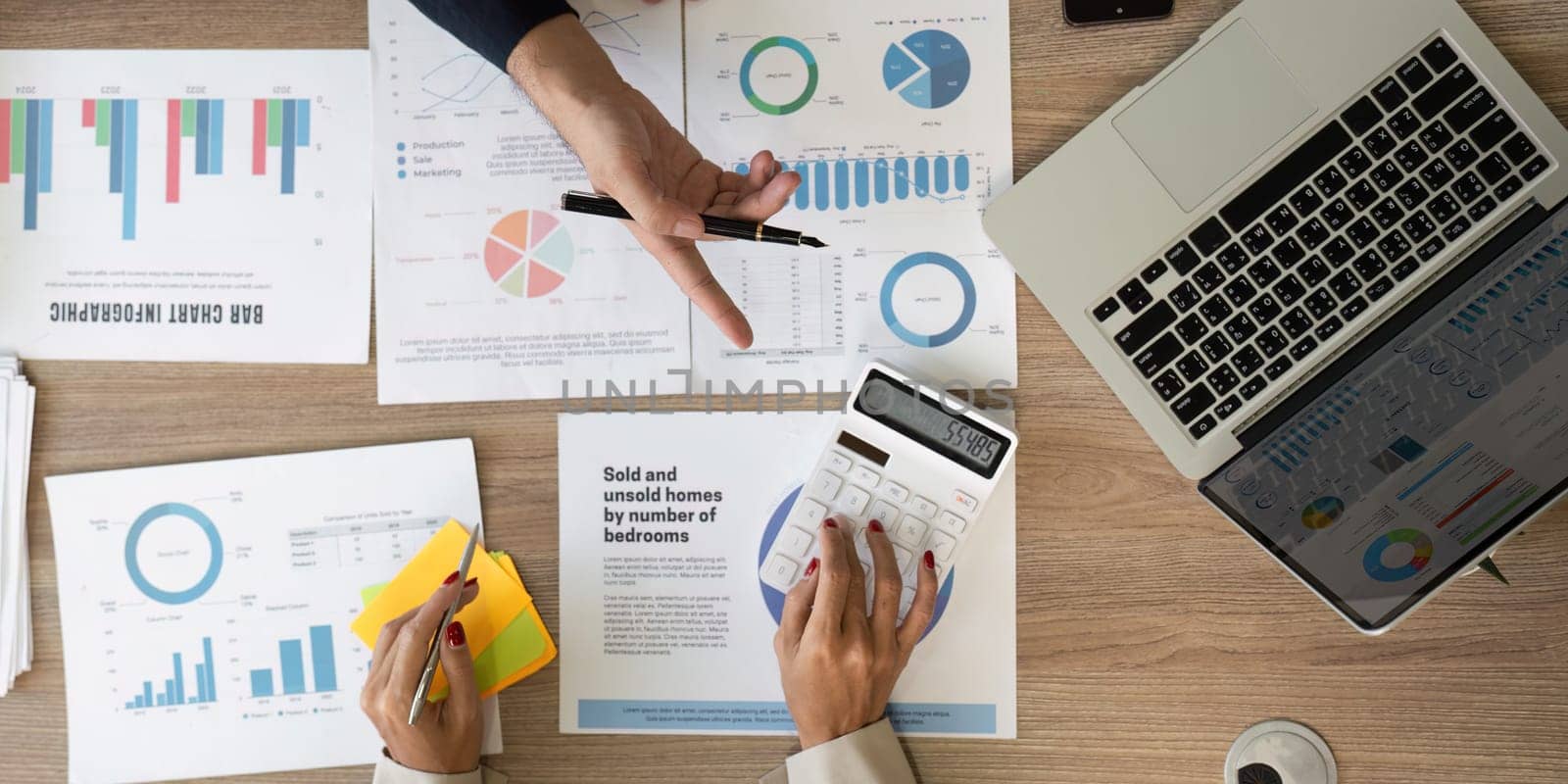 An overhead view of business reports, financial data, and a calculator on a modern workspace table.